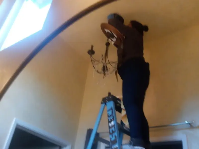 Electrician installing a chandelier in a Campbell residence